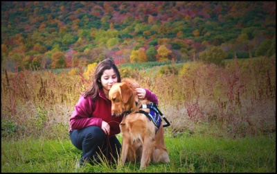 Bradley and I embracing with a colorful Autumn scene in the background